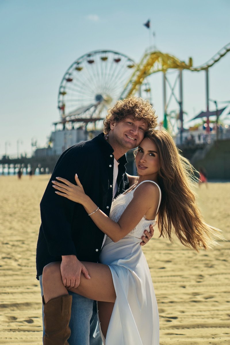 Couple on the Beach by a Seaside Amusement Pier