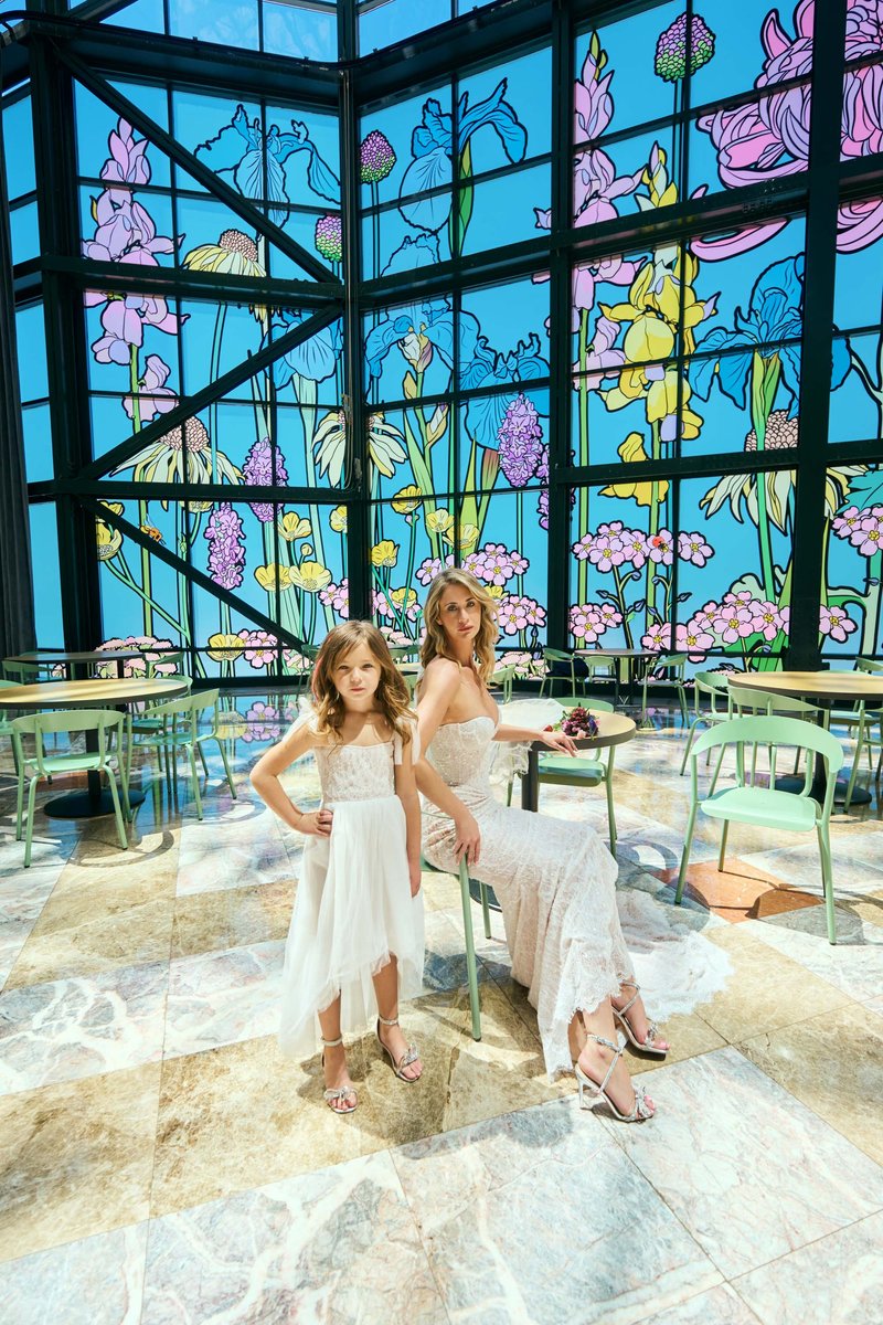 Mother and Daughter by a Stained-Glass Atrium Wall