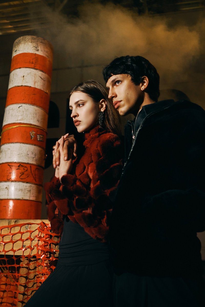 Couple in Fur by a Construction Barrier at Night