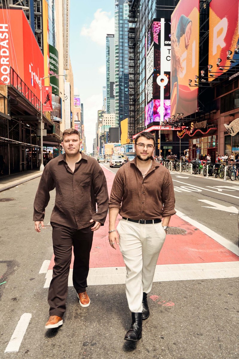 Two Men Walking Through Times Square