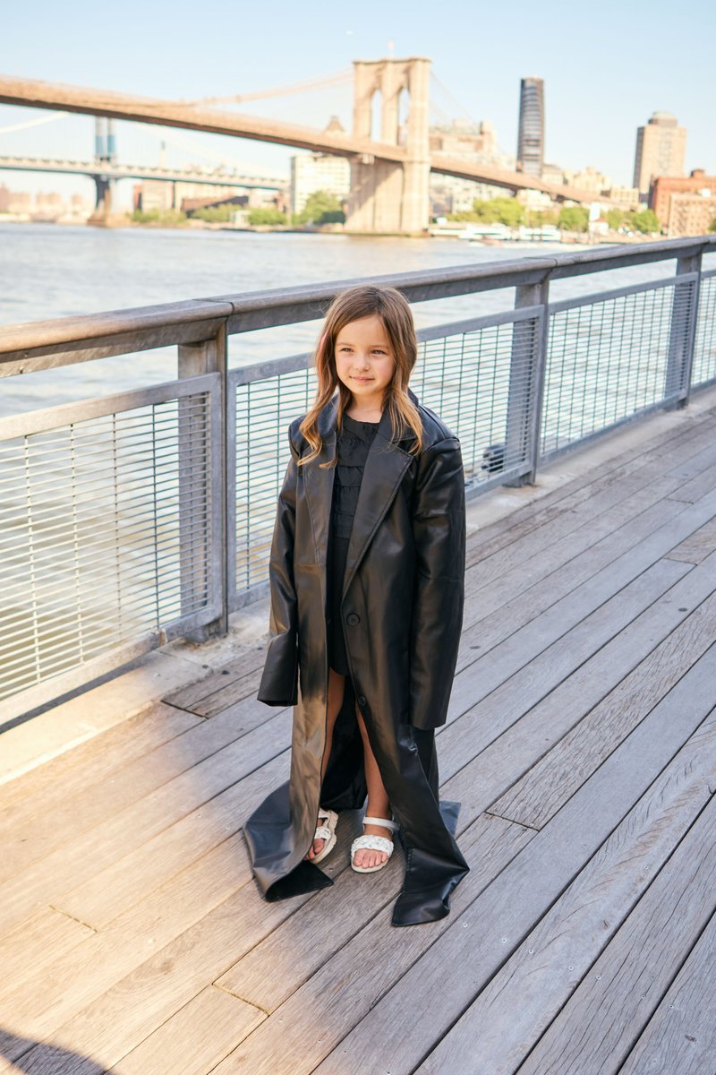 Girl in an Oversized Coat on the Seaport Boardwalk