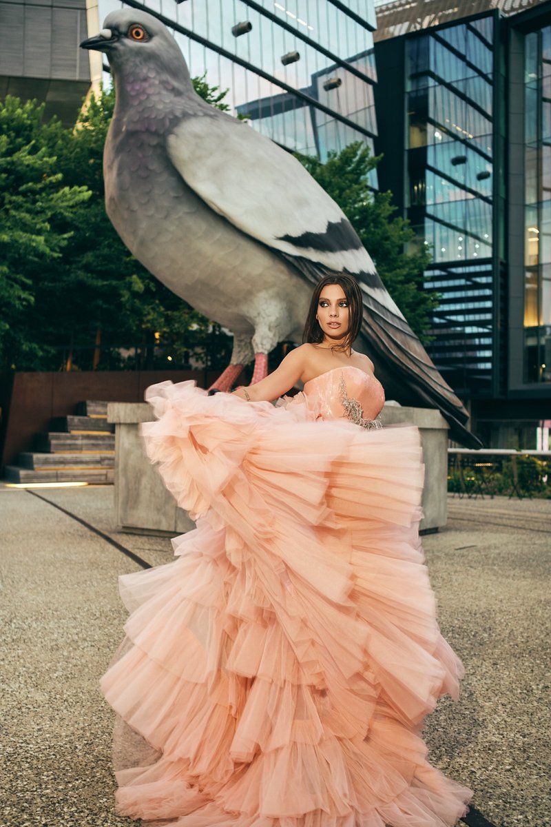 Model in Blush Tulle Beside a Giant Pigeon Sculpture